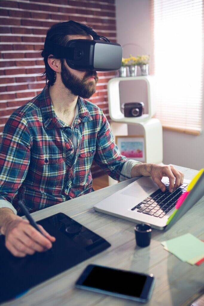 Gaming app developer using VR headsets and laptops for 3D game development